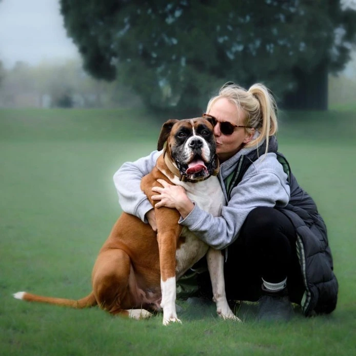 A portrait image of Claire, with a dog.