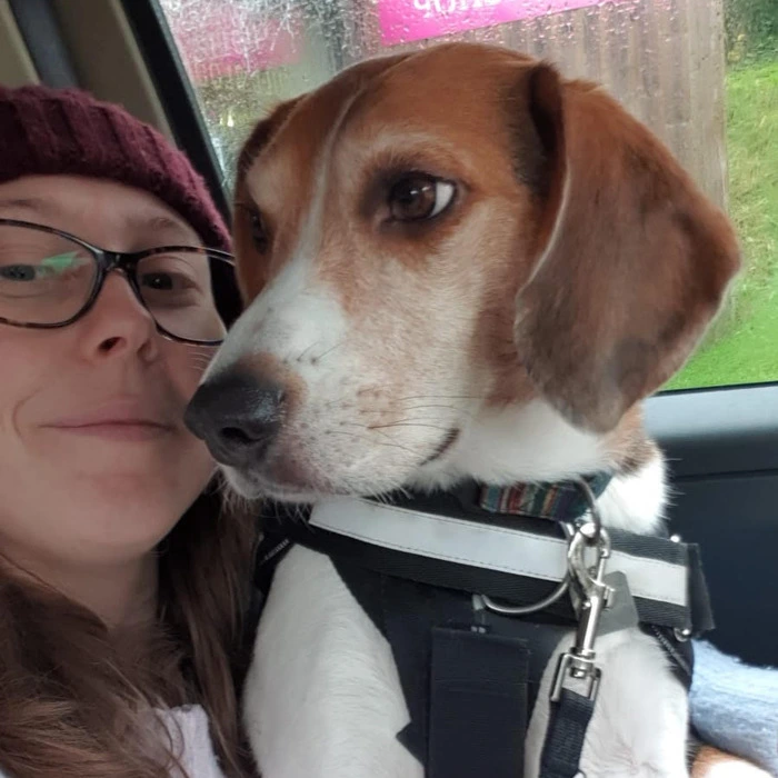 A portrait image of Georgia, holding a dog.